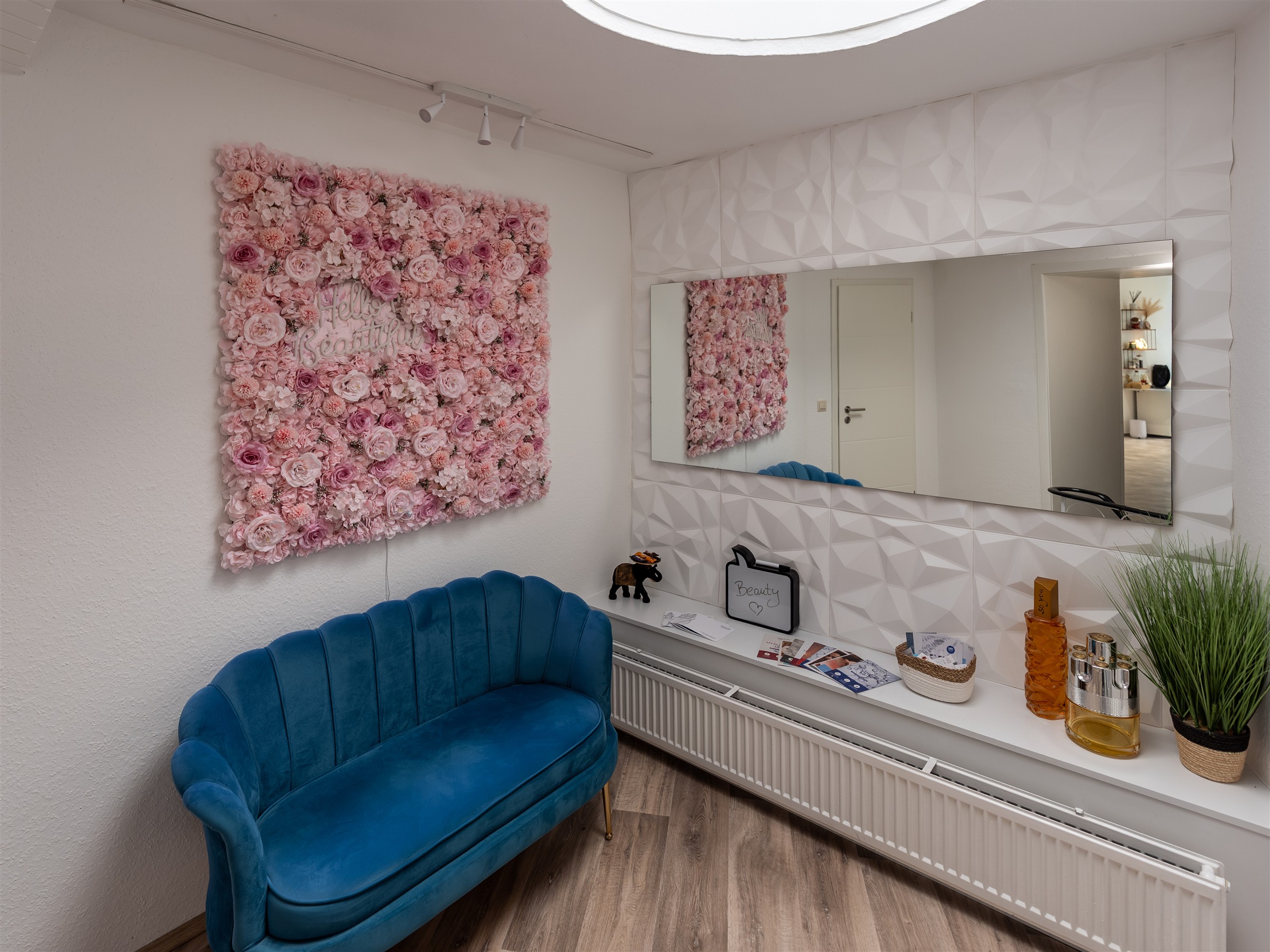 Wartebereich mit Blumenwand und blauem Sofa